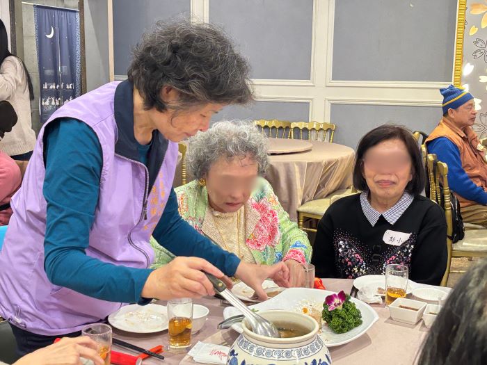 《圖說》志工們在圍爐中與長輩們寒暄與貼心夾菜。〈林口公所提供〉