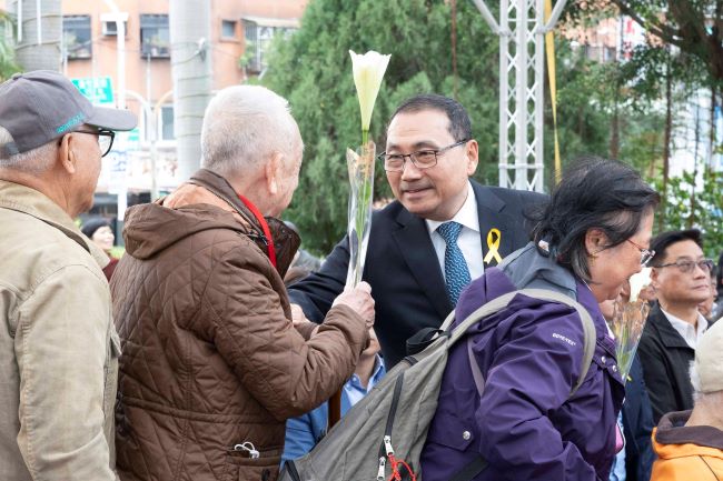新北悼念二二八79周年 侯:盼團結台灣傳承和平信念 7 《圖說》侯友宜市長逐一遞送鐵炮百合給受難者家屬獻花,撫慰受難者心靈。〈民政局提供供〉