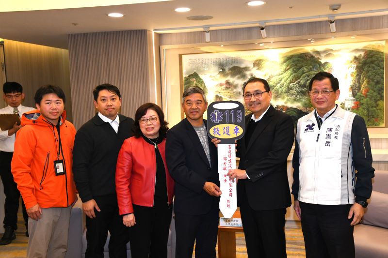 《圖說》捐贈者致贈救護車鑰匙(鑰匙左側依序為，王淄岑總裁、鄭秀敏總裁夫人、總裁之子王俊傑董事長、總裁之子王俊翔主任，右一為消防局長陳崇岳。〈消防局提供〉