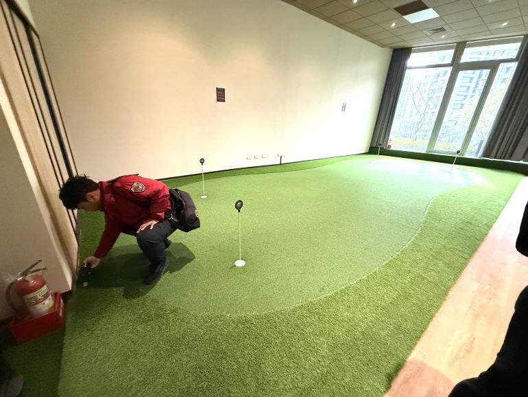 《圖說》消保官會同消防局查核室內高爾夫球模擬器練習場草皮防焰標示情形。〈法制局提供〉