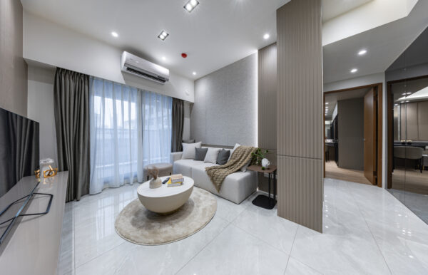 「皇逸居」室內實景示意，以大面落地窗引入自然採光，搭配溫潤木質與簡約設計，營造明亮舒適的都會居家氛圍。圖/業者提供