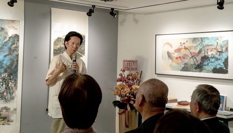 《圖說》劉易齋教授解說明月師的魚游自在、荷花清淨的超脫俗塵畫作。〈主辦單位提供〉