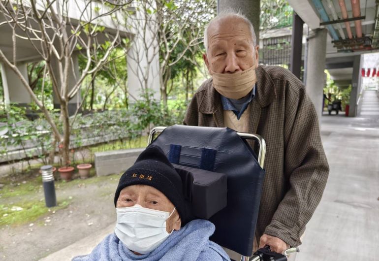 《圖說》推輪椅，杜祖培（前）、張文坤（後）。 〈照片張長林提供〉